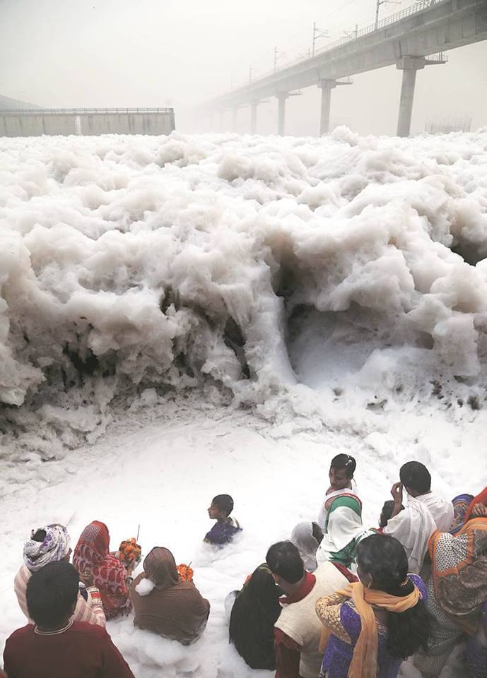 India: People pray in a river of industrial waste in India