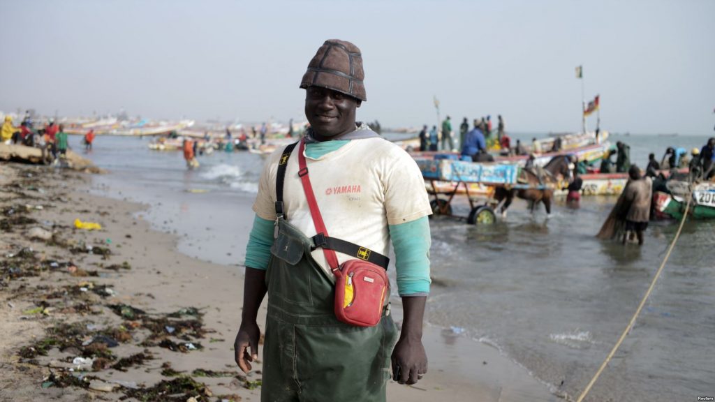 Doudou Kote, the captain of a Senegalese fishing vessel, stands on the beach at Joal-Fadiouth, a hub of the country's fishing industry,