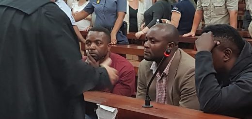 Advocate Terry Price, left, consults with the rhino poaching gang after they were found guilty in a Makhanda court. From left are Jabulani, Forget and Sikhumbuzo Ndlovu. Image: Adrienne Carlisle